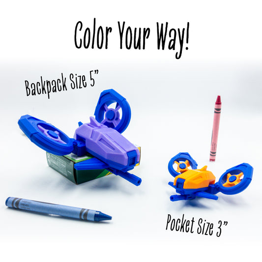 DosFly the dual drone toy displayed in multiple bold colorways with “color your way!” above—highlighting its modular and collectible appeal, two sized versions beside a crayon, showcasing scale