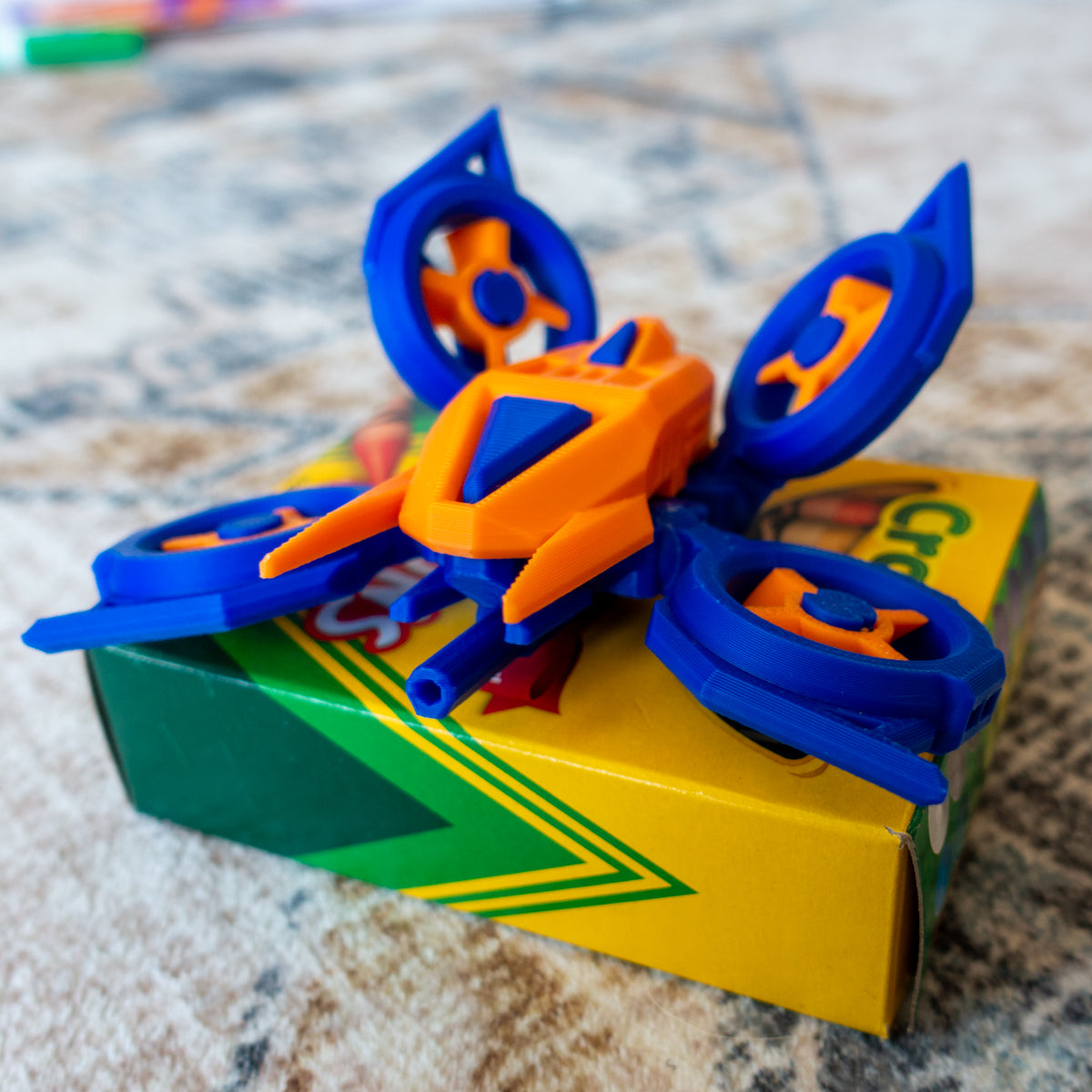 Huvver the Quad Copter shown mid-hover on carpet, with flexible parts and reconfigurable rotors