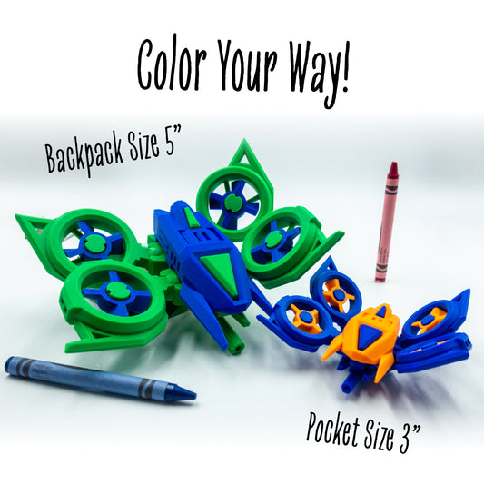 Huvver the Quad Copter toy shown in custom colorways under the “color your way!” message—engineered for creative reassembly. Shown near crayons for scale difference between the 5" and 3" versions.