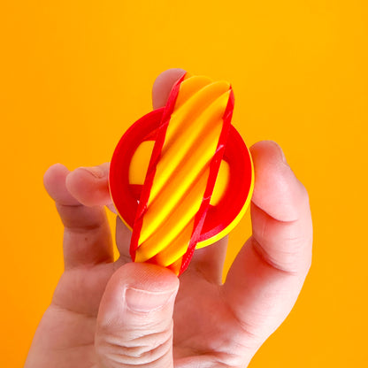 A yellow and red fidget spinner with a gyro center and groovy outer texture