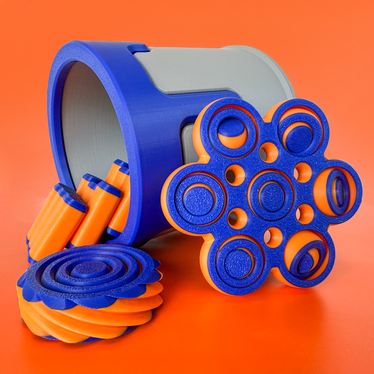 3 blue and orange fidget toys on an orange background
