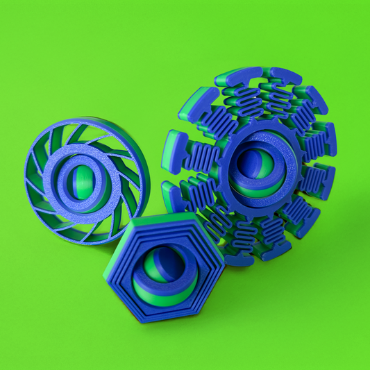 Three green and blue fidget toys on a green background.