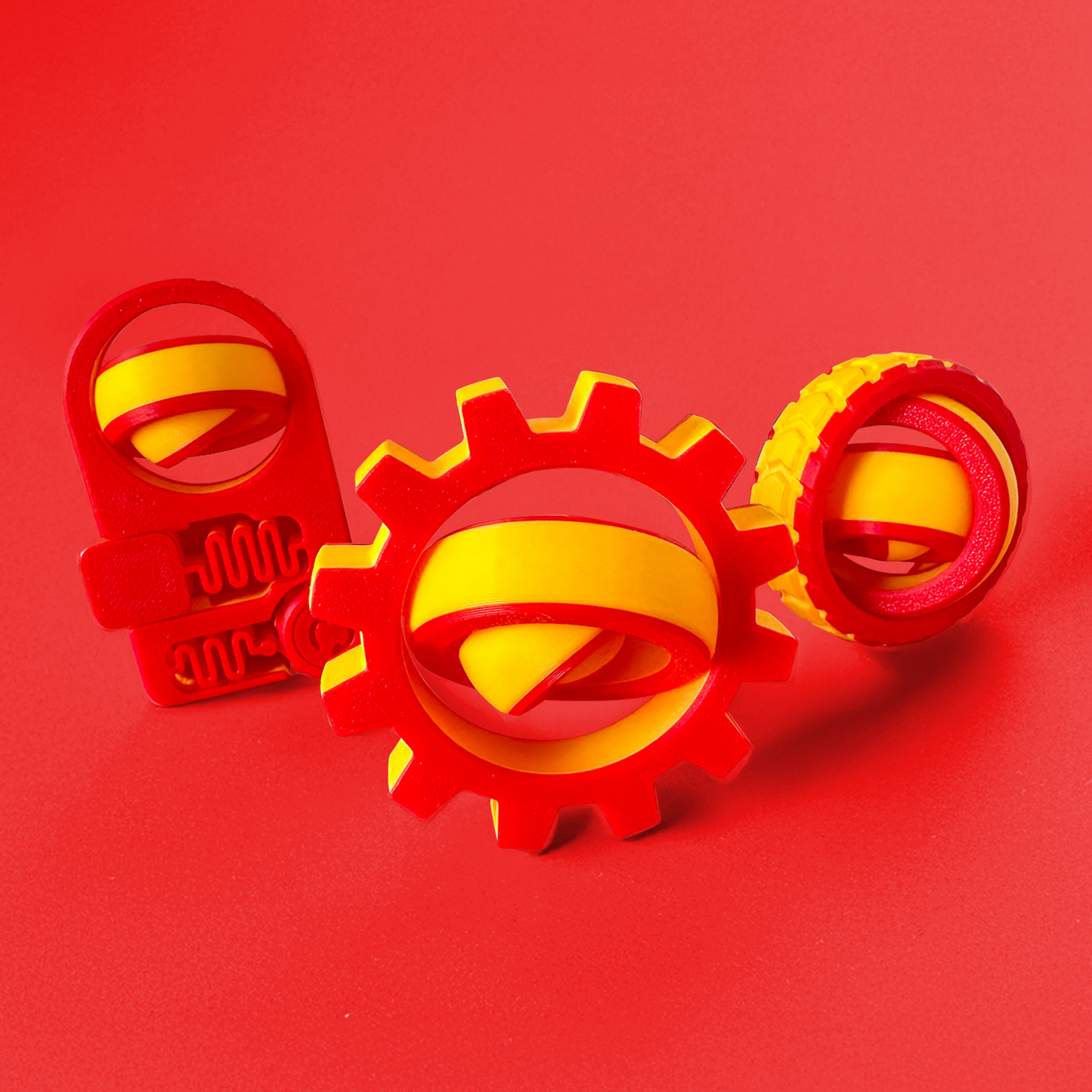 Three red and yellow fidget toys on a red background.