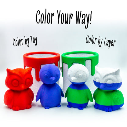 Two pairs of Hoot the owl and Waddle the penguin toys paired beside a collectible paint can, illustrating desk-friendly size and collectible appeal