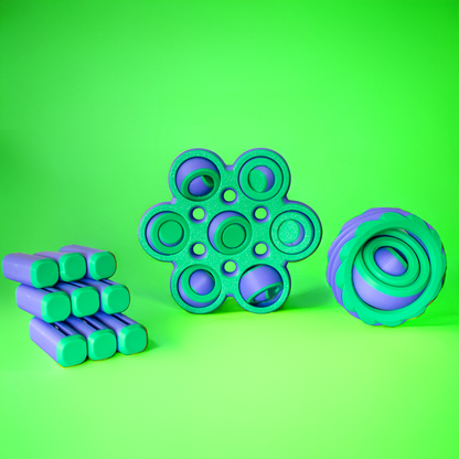 Three green and purple fidget toys on a green background.