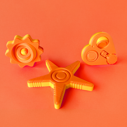 Three orange and yellow fidget toys on an orange background.