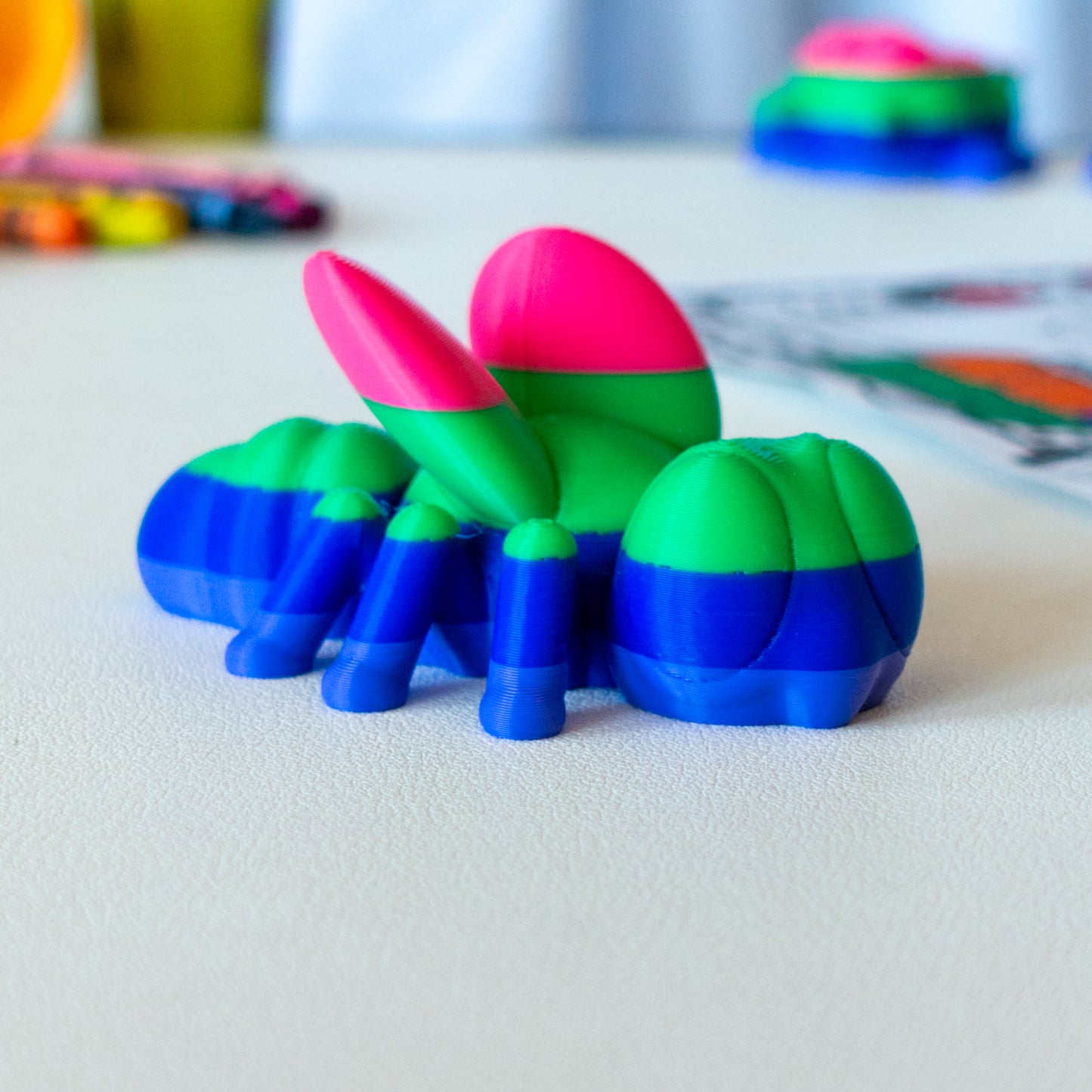 Zipp Fly custom articulated animal toy posed on a coffee table, designed for tactile play and fidget-friendly movement